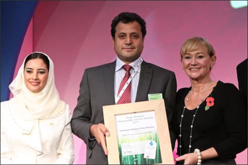 Najeeb Ahmed Khan holding the Responsible Tourism Award on stage at World Travel Market, London